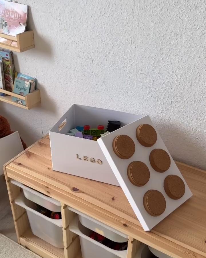 White storage box with cork circles mimicking ikea lego storage hacks & ideas from @interiorundco. Gold lettering detail.