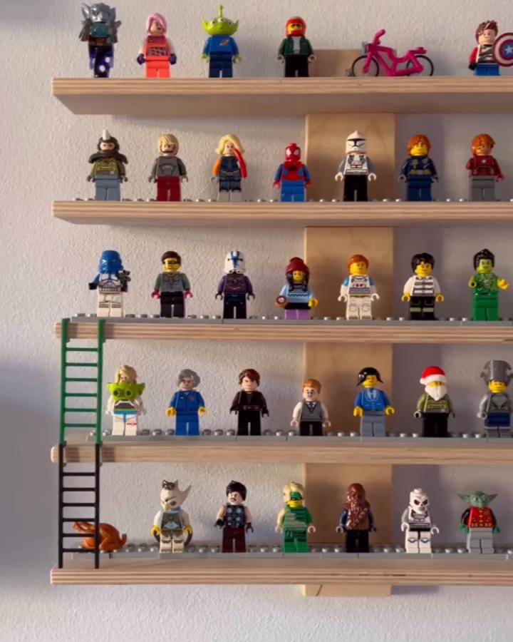 Natural wood Lustigt shelving unit from @malene.baekgaard displaying colorful minifigures in organized rows with ladder accent.