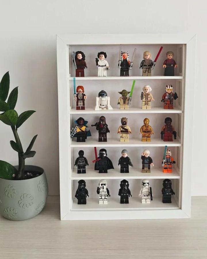 White framed display shelf from NoOrdinaryLeaf showing organized minifigure collection with custom grid compartments