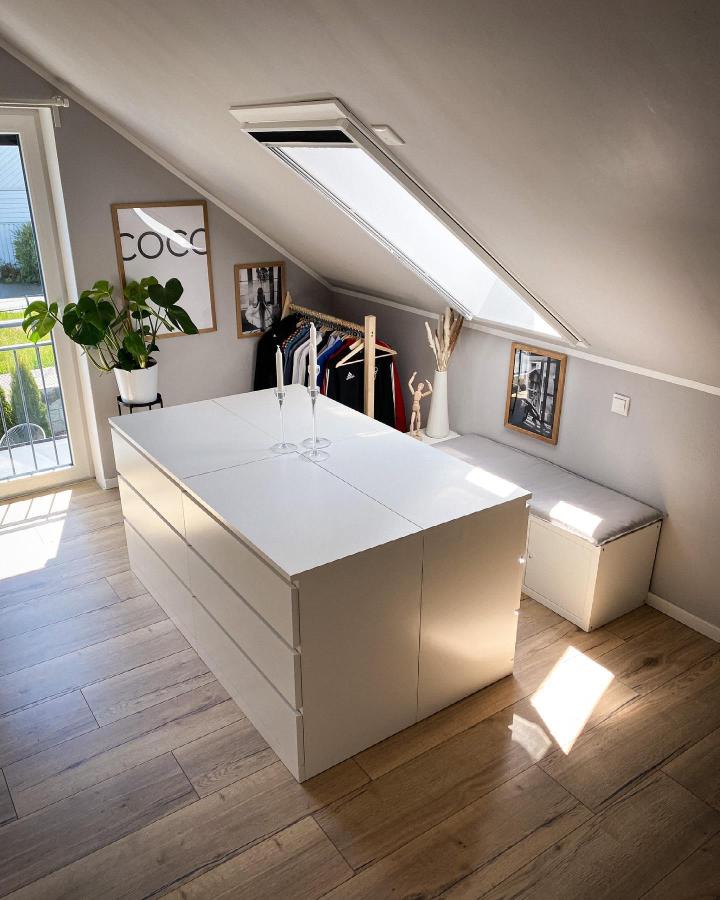 white sleek storage island and bench in attic room from @family.lang_official. Modern ikea malm hacks & ideas with skylight and natural light