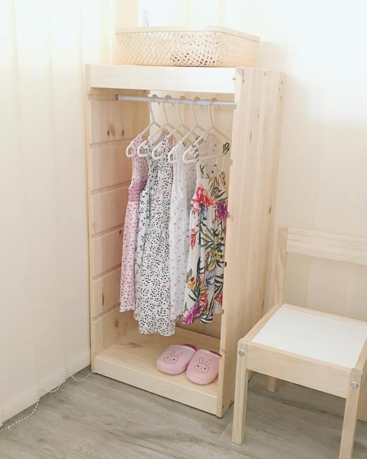 Natural pine Trofast wardrobe showcasing ikea montessori hacks & ideas from @_ciccibombi. Child-height hanging rod with colorful dresses.