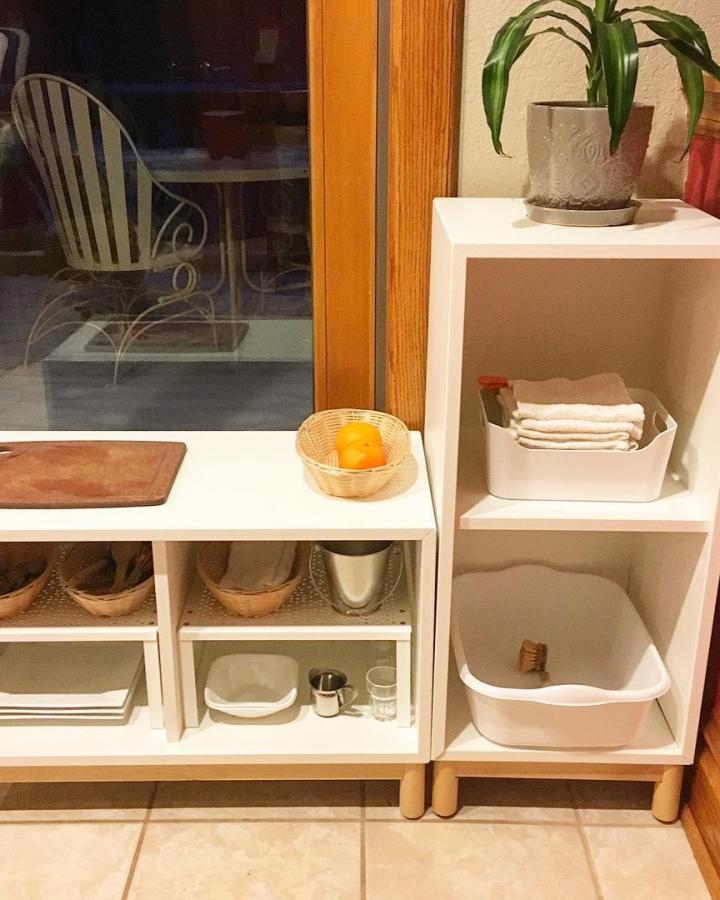 White Eket play kitchen setup from @crystalsofsnow featuring ikea montessori hacks & ideas with natural wood accessories.