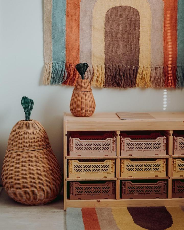 Natural pine Trofast unit with colorful recycled storage crates from @viivivalokainen. Woven decor accents nearby.