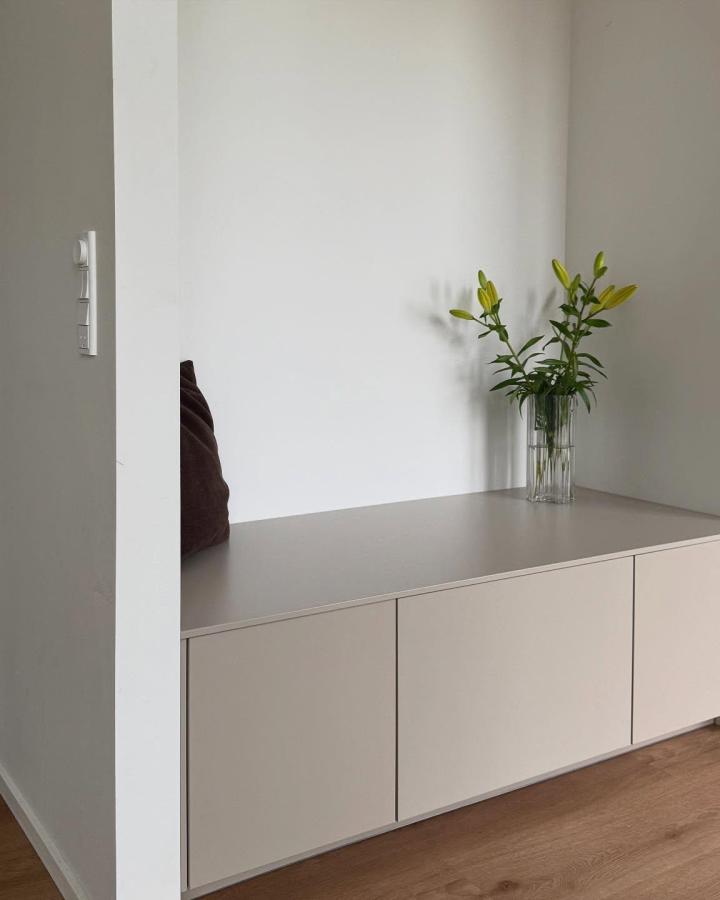 Minimalist matte beige storage bench and plant arrangement from @nybygger_nordjylland21. Quiet, clean-lined corner solution.