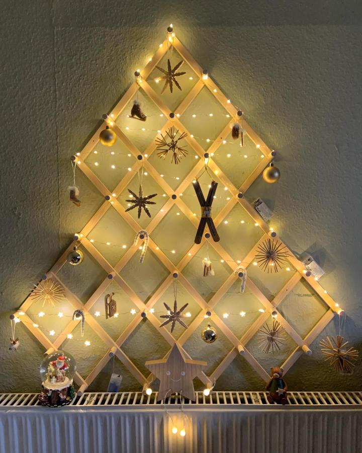 Wooden lattice tree display from @mamadurchacht showcasing ikea vinterfint hacks & ideas with ornaments and string lights.