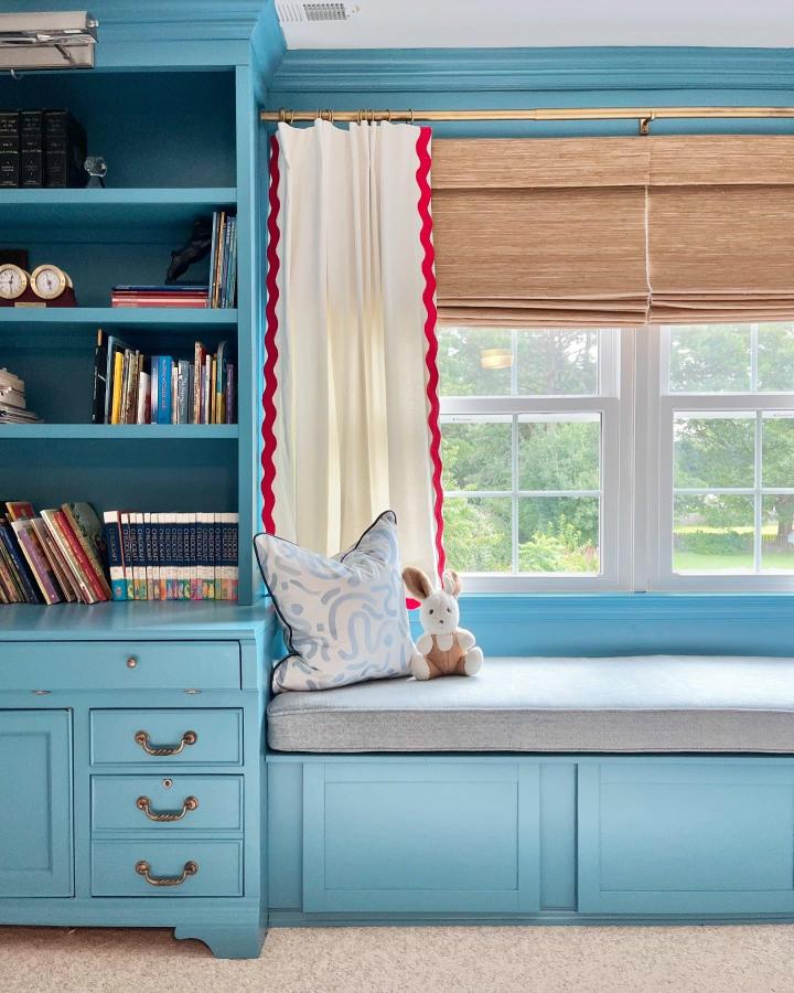 Turquoise painted built-in window bench from @holymackerelhouse with brass hardware and cushioned seating.