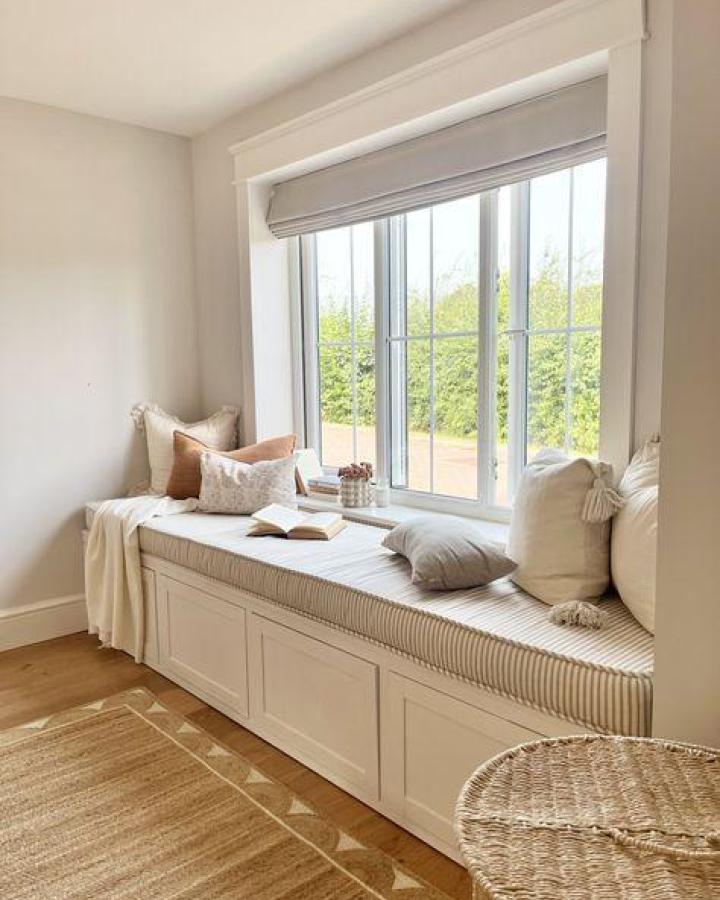 Neutral striped window seat showcasing ikea window bench hacks & ideas from Fourth Home with layered cushions and garden views