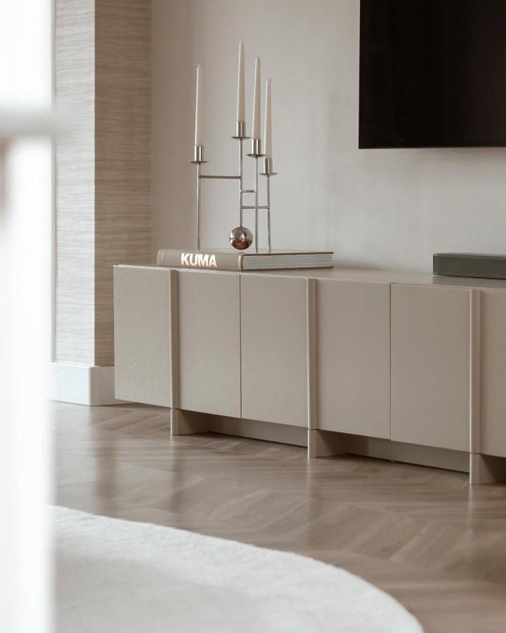 Taupe Ikea Besta console from @veer.enmeer with brass candleholders and neutral styling in modern living space.