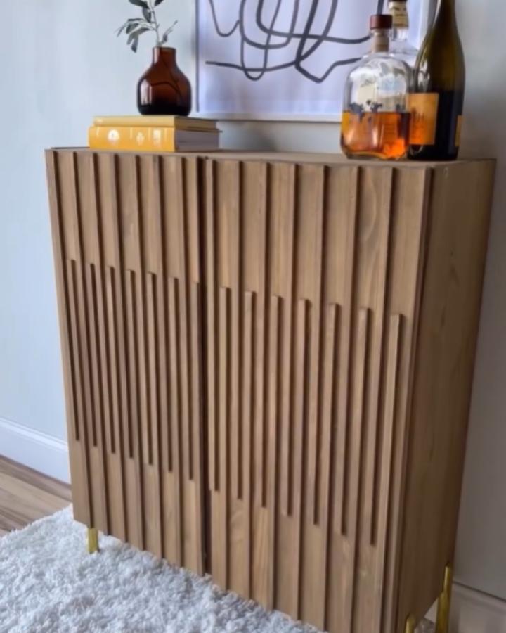 Fluted wood cabinet from @pretty_distressed with vertical dowel detailing and brass leg accents.