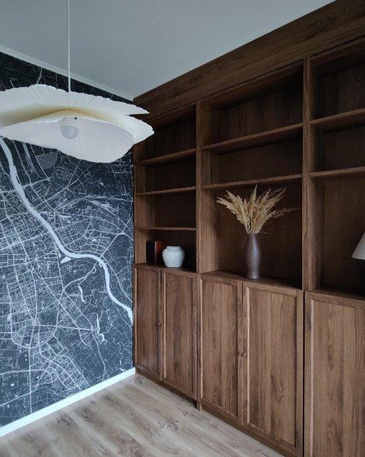 dark walnut wood built-in bookcases in a modern room from @usiebiewdomu with built-in storage and decor