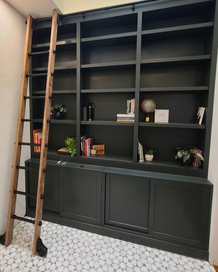 dark green painted Billy bookcase with wooden ladder in patterned tile room from @redunnhomes showcasing ikea billy bookcase hacks & ideas