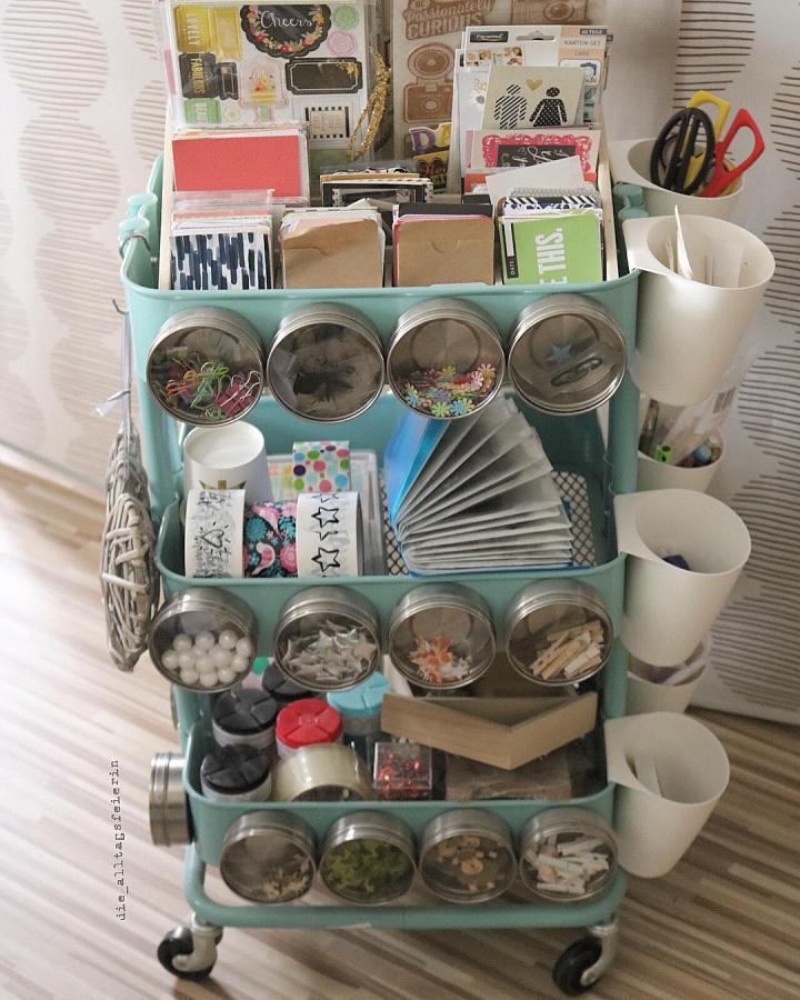 mint green rolling craft cart with magnetic jars and white cups from @die_alltagsfeierin organized ikea craft room storage hacks with colorful small items