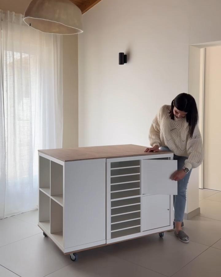 white minimalist craft table with sliding doors and shelves on wheels in bright room ikea kallax craft table hacks from @madamebblog practical storage and workspace