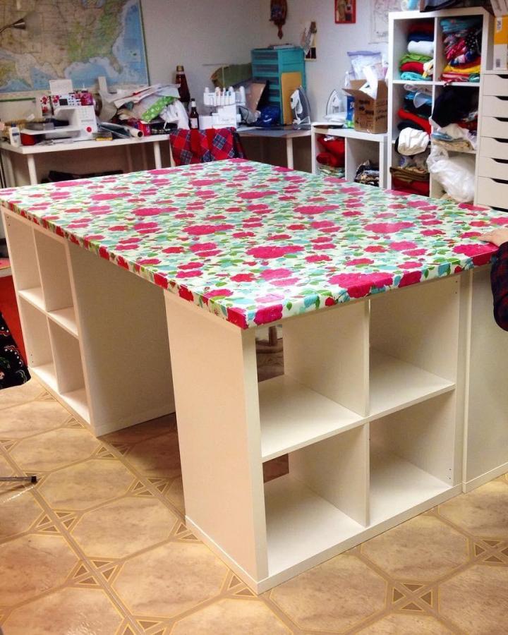 White Ikea Kallax units with floral laminated craft table surface in a busy sewing room ikea kallax craft table hacks