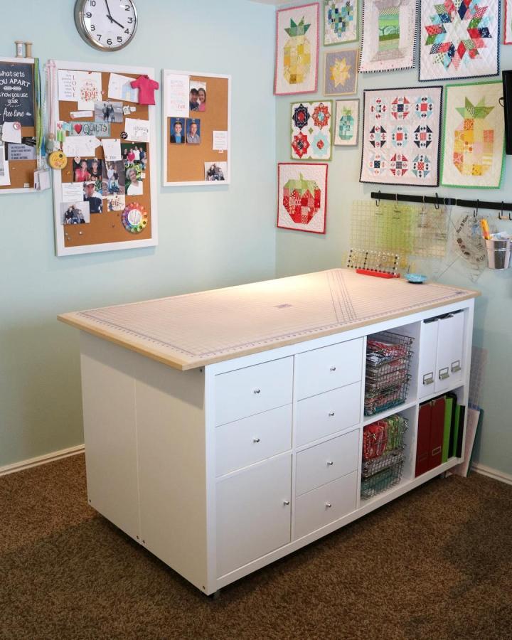 White Ikea Kallax craft table with drawers and wire baskets in a craft room by @abrightcorner showcasing ikea kallax craft table hacks.