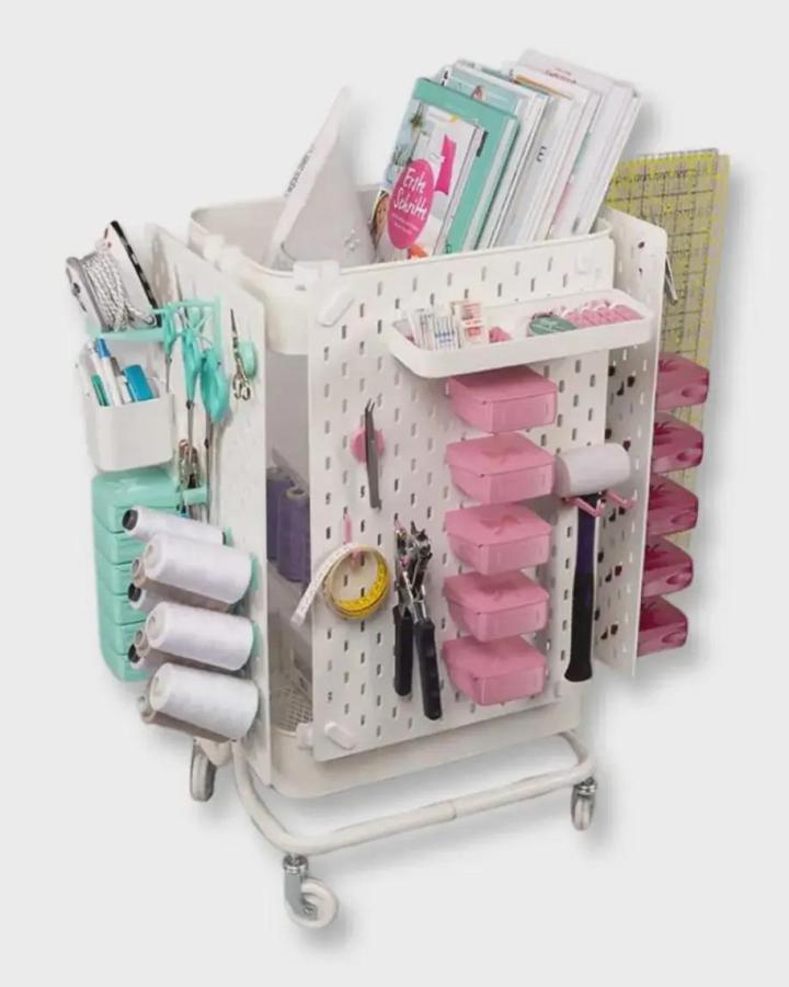 white rolling cart with ikea skadis pegboard craft room hacks holding pastel pink and mint green storage containers and craft supplies