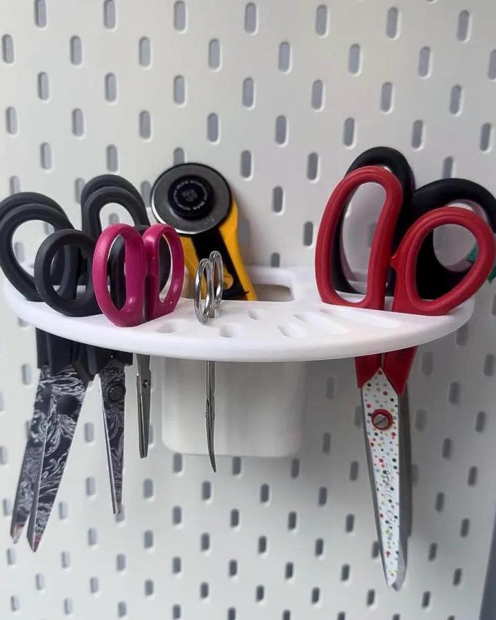 white pegboard craft room scissor holder from Integrity3Designs ikea skadis pegboard craft room hacks with organized scissors and rotary cutter