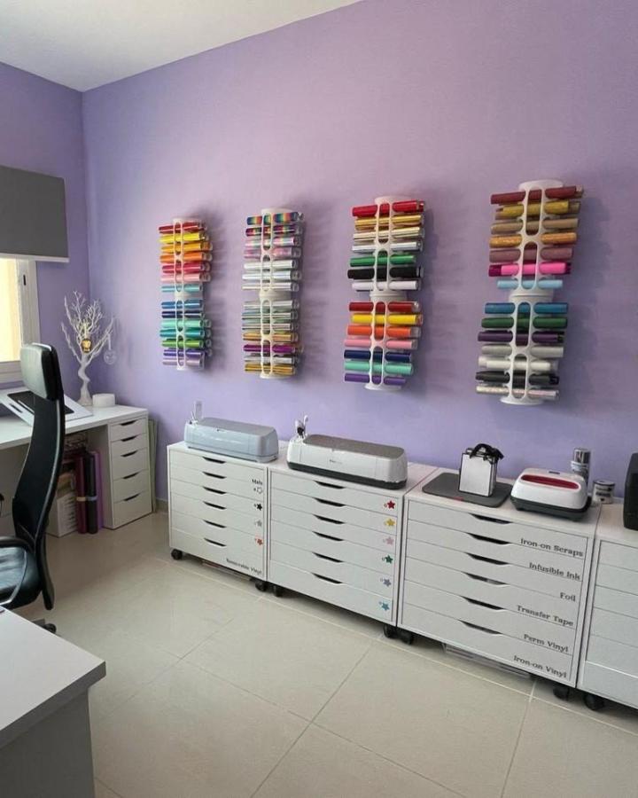 white Ikea Alex Drawers craft room from @glitter_arty_uae with colorful vinyl racks and labeled storage for neat ikea cricut storage ideas