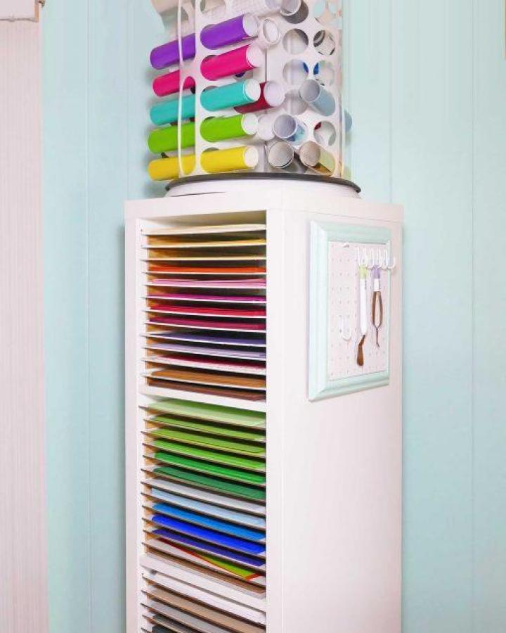 White Ikea Kallax inspired vertical paper storage unit with pegboard and vinyl roll holder from Jennifer Maker for ikea cricut storage ideas.