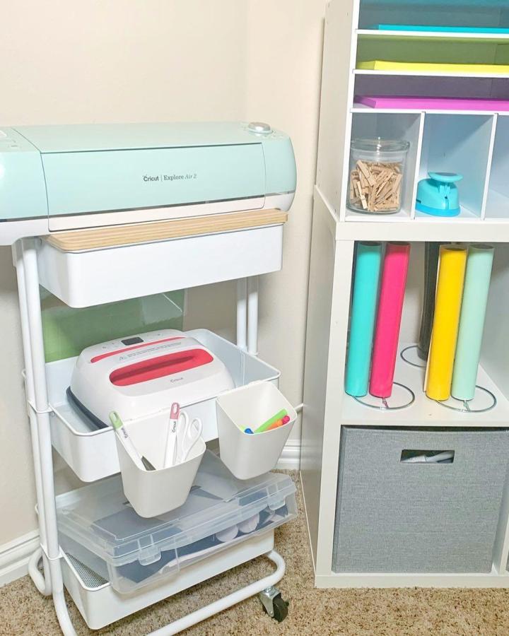 White Ikea Raskog cart with pastel Cricut machines and white bins from @aperfectblendteaching neat ikea cricut storage ideas.
