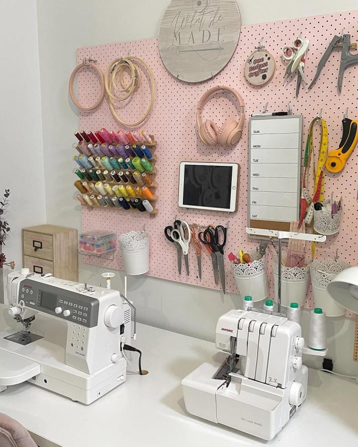 Pink Ikea Skadis pegboard sewing space from @what.she.made with organized scissors, threads, and hooks for ikea sewing room hacks & ideas.