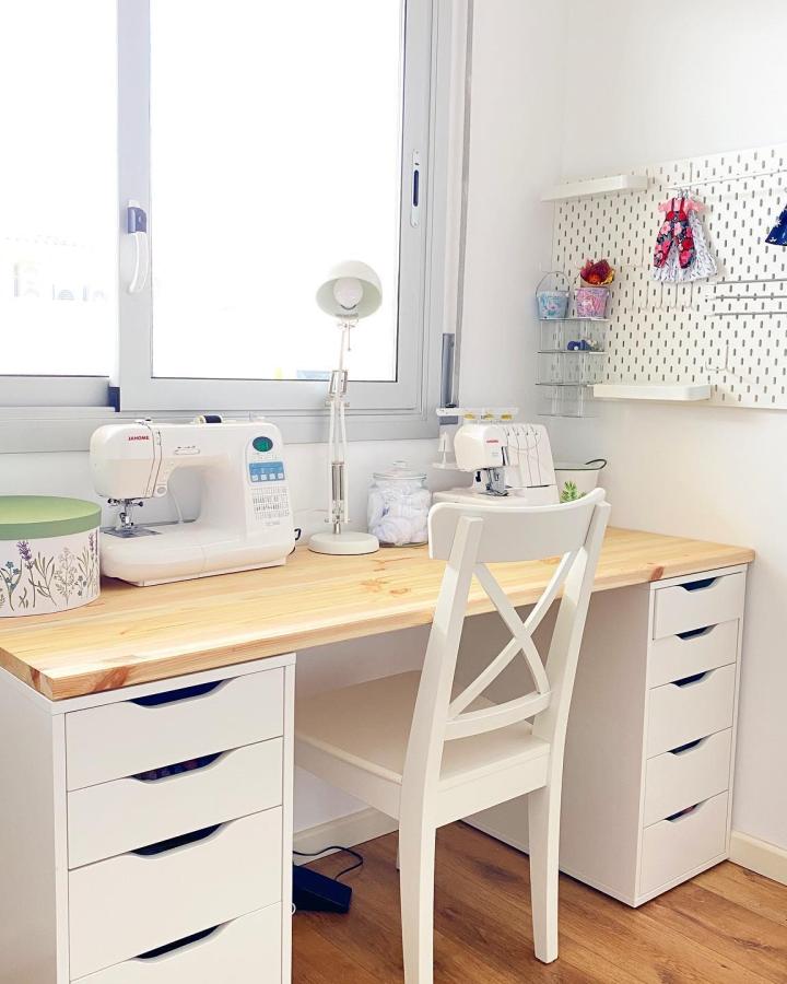 White Ikea Alex drawer units with wood desktop and pegboard wall from @artdollhouse_ bright sewing nook with organized craft tools perfect for ikea sewing room hacks & ideas.