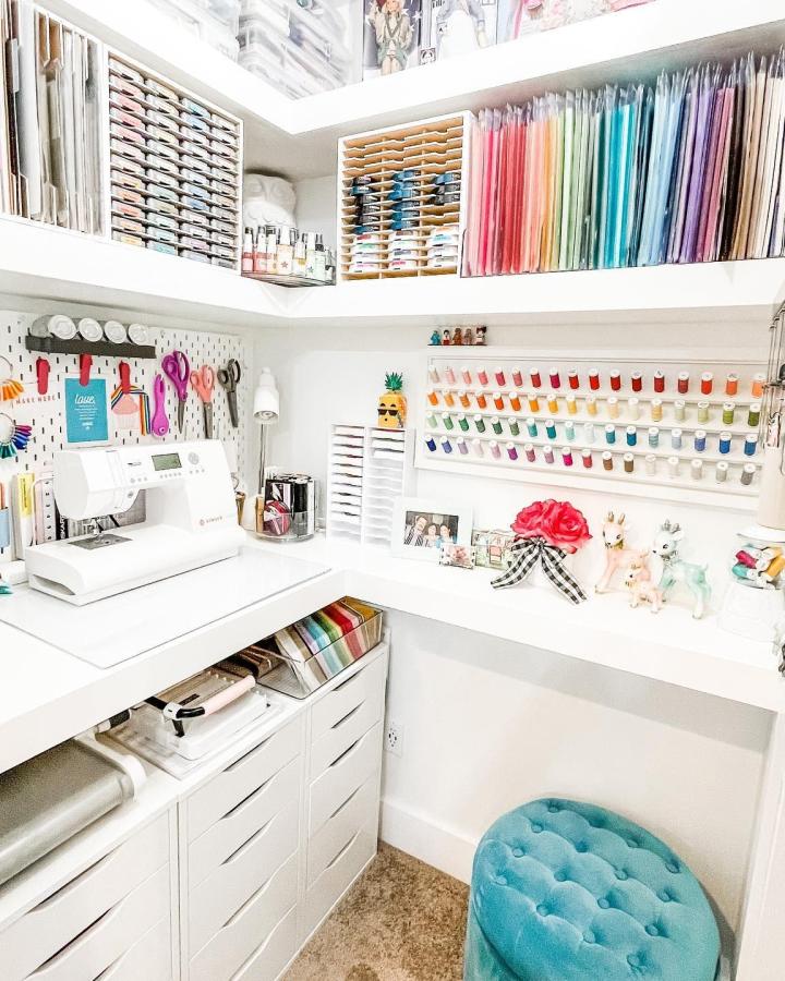 Bright white closet sewing room with Ikea Alex drawers and Skadis pegboards from @laura_evangeline. Colorful thread display and organized craft space.