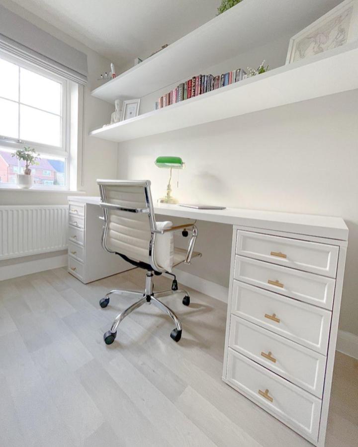 Bright white Ikea Alex desk hacks & ideas workspace with gold handles and floating shelves from @our_camberley_home.