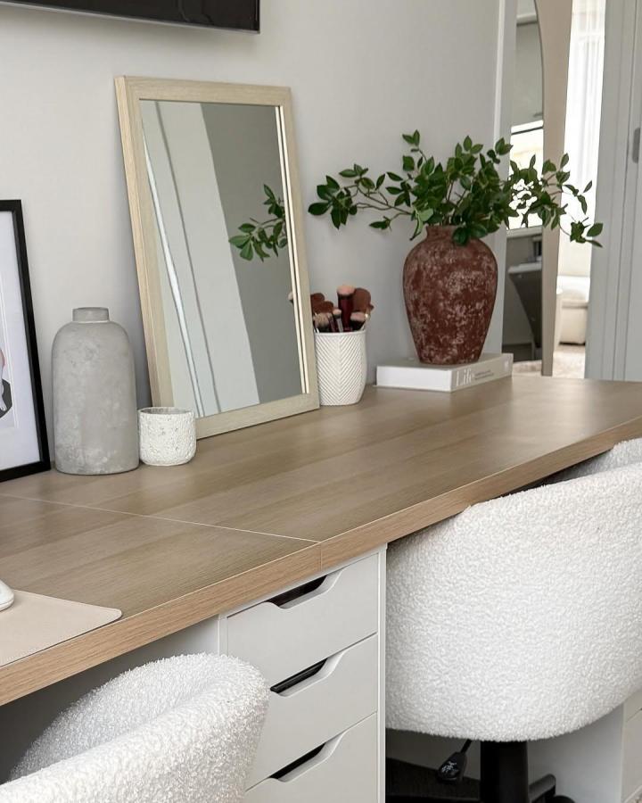 Light wood topped Ikea Alex desk with white drawers and bouclé chairs from @ozaygiz featuring terracotta vase and cozy workspace elements.