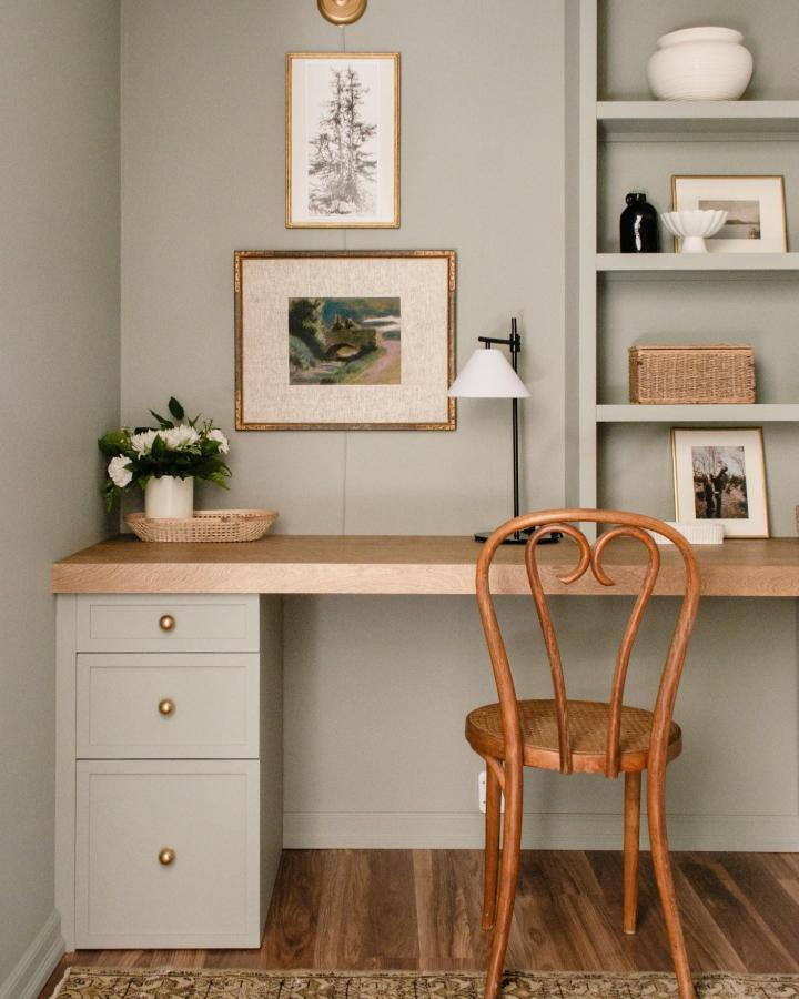 Muted sage green Ikea Alex desk hacks & ideas with natural wood top and vintage chair from @jyllmackiehome. Warm, cohesive workspace design.
