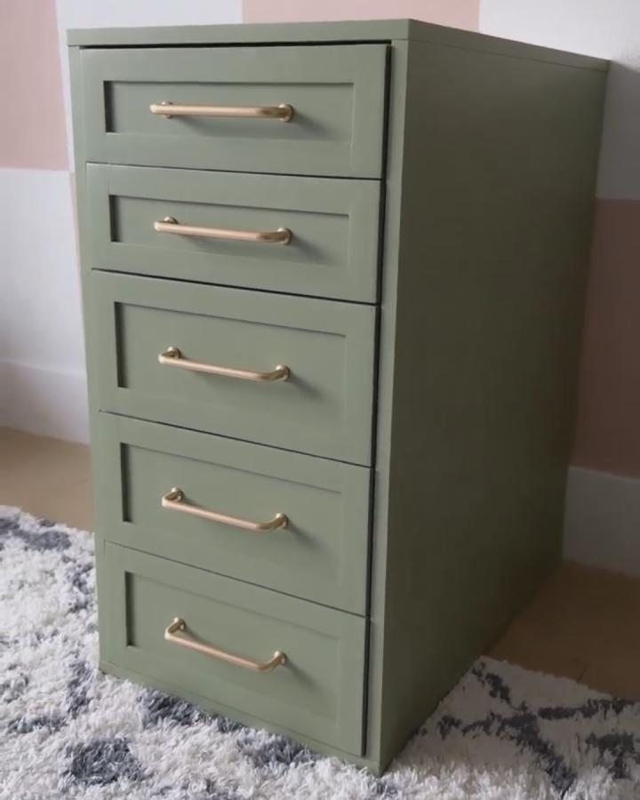 Soft sage green Ikea Alex desk hack with brass handles on a textured rug from @parkplaceabode. Chic modern desk storage idea.