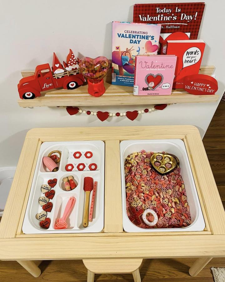 Natural wood kids play table from Christina Ann with Valentine’s themed storage bins and festive decorations ikea flisat table hacks & ideas