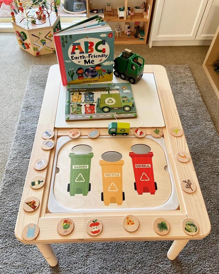Natural wood Ikea Flisat table hack with recycling bins and sorting tokens from @learning.with.jo promoting eco-friendly play.