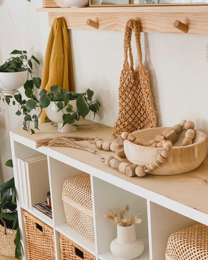 Natural wood and woven basket Ikea Kallax styling ideas from @jcdesign1.1 with plants and earthy accessories.