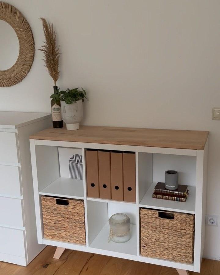 White and natural wood Ikea Kallax with woven baskets and simple decor from @newswedishdesign showing rustic and modern ikea kallax styling ideas.