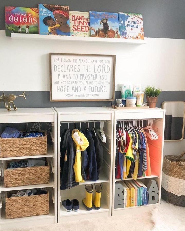 White open wardrobe with colorful coral backing and baskets displaying organized kids clothing and books ikea kids wardrobe ideas by @mommodesign
