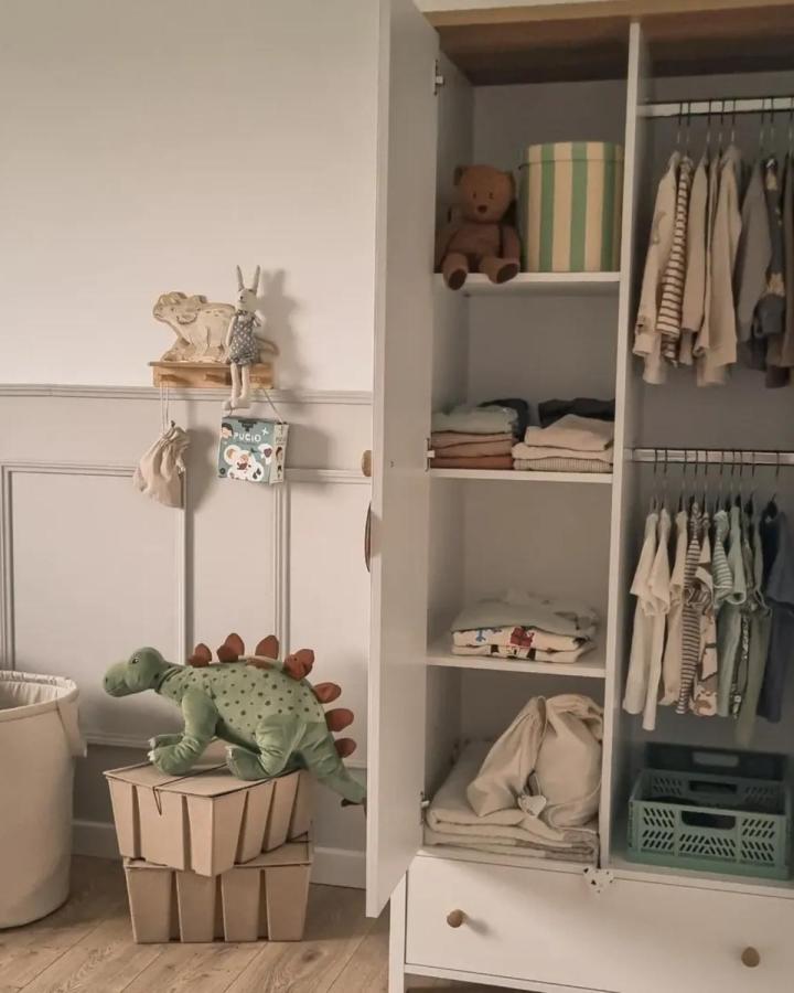Soft neutral kids wardrobe from @makowy_dom with open shelves, hanging clothes, and cozy storage bags in natural materials.