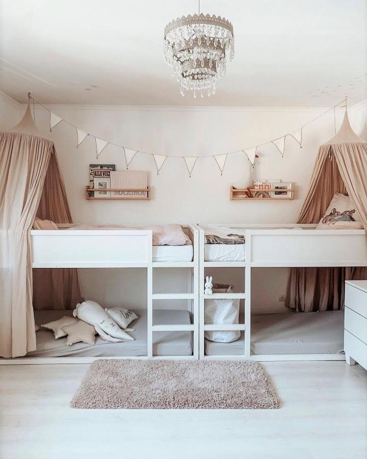 Two white ikea kura bed ideas for small rooms with beige curtains creating private lower play nooks and cozy upper beds from @kate.andthegirls.