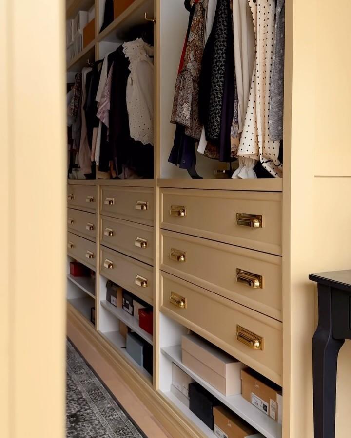 Beige painted Ikea Pax drawers with golden pulls in a walk-in closet by @johannainteriors showing neat shoe storage below.