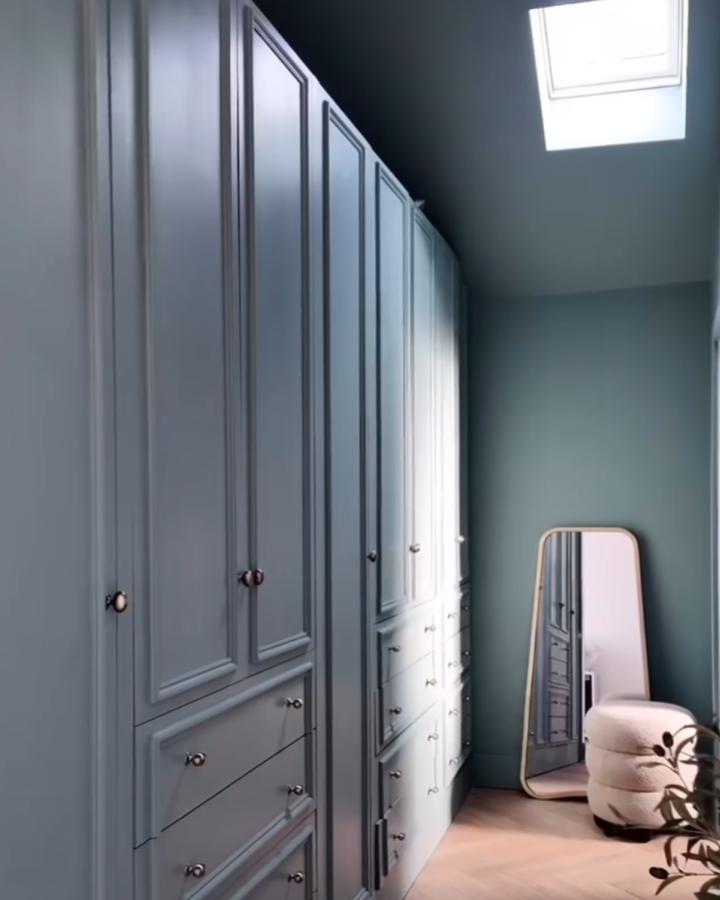 Painted blue-gray panelled Ikea Pax closet in walk-in with mirror and plush stool by @our_bears_home in ikea pax hacks for walk-in closets.