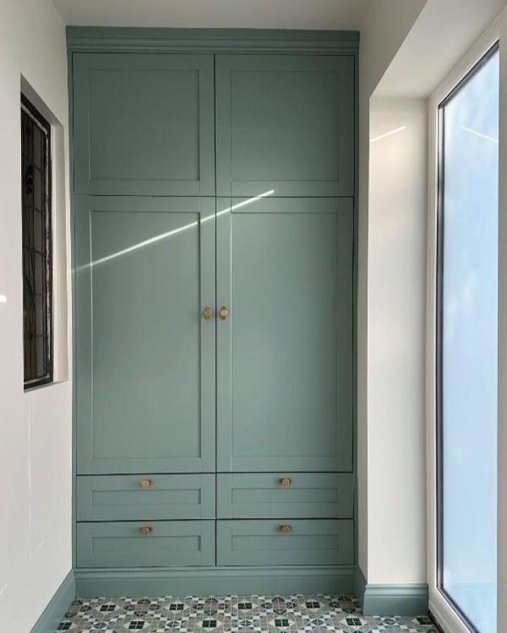 Muted green painted platsa storage with brass knobs and crown molding in an alcove from @jennyhuebner_ showing ikea platsa hacks for awkward alcoves.