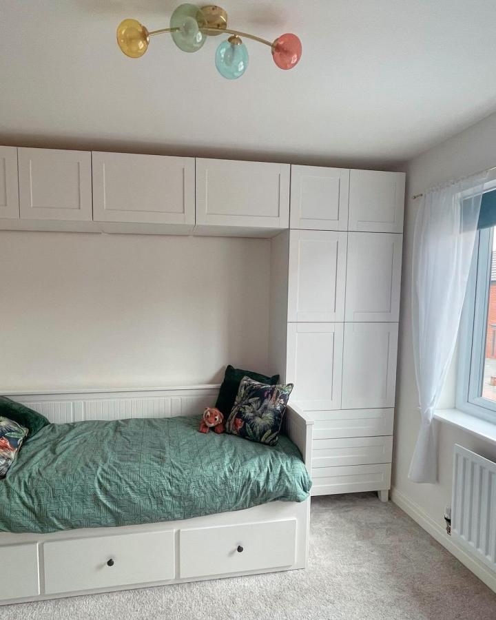 white built-in storage and daybed in small bedroom using ikea platsa hacks for small bedrooms with green bedding and floral pillows
