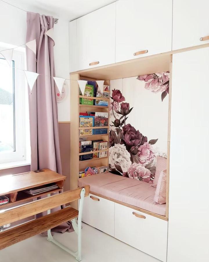 Soft pink cushioned nook with white Ikea Platsa cabinets and floral wallpaper from @thenaylorsnewbridge in a small bedroom ikea platsa hacks for small bedrooms.