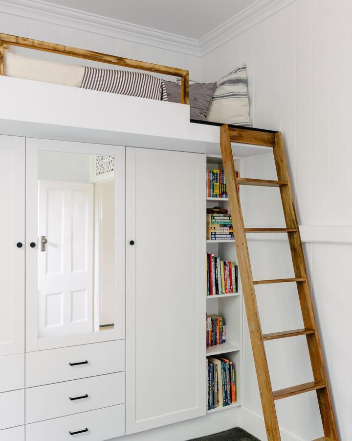 White and wood loft bed with integrated bookshelf and wardrobe from @bayluproperties ikea platsa hacks for small bedrooms