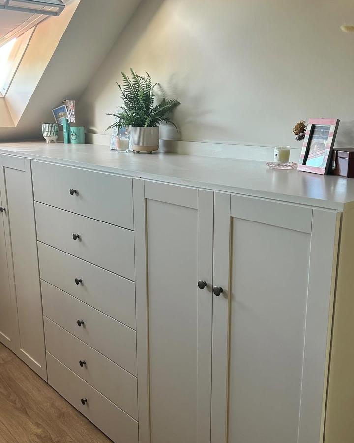 White flat-panel Ikea Platsa cabinets for small bedroom storage with black knobs and plant accents from @bones.home.barnes.