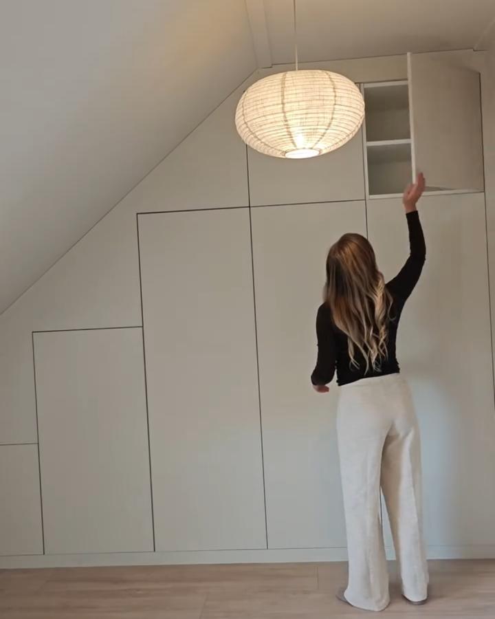 White minimalist built-in storage wall from ikea platsa hacks for small bedrooms by @thuisbijthira with sloped ceiling integration and concealed cabinet doors