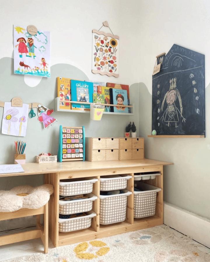 Light wood and plaid fabric bins Ikea Trofast playroom ideas from toddleandplay with chalkboard and art display creating a cozy, organized kids space.
