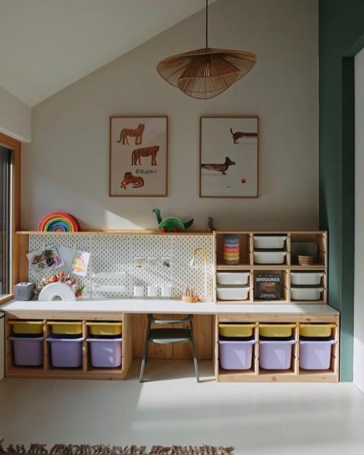 Lilac and yellow storage bins in wooden frame ikea trofast playroom ideas by @lthekidsroomdesign with pegboard and art above.