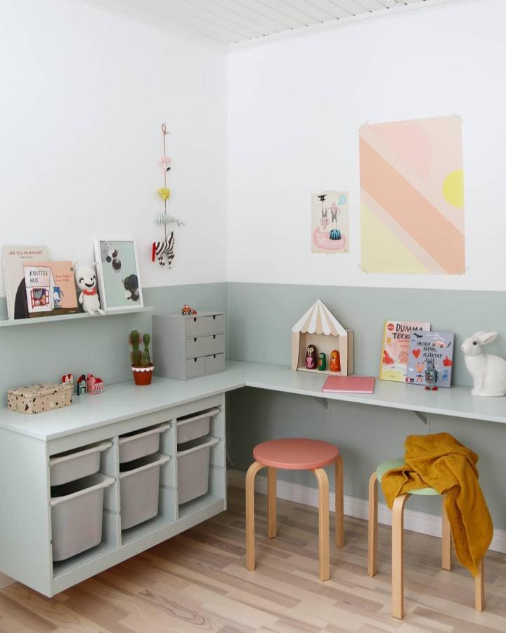 Muted green and white Ikea Trofast storage corner with pastel stools from @hemlikheter. Soft, tidy playroom design.