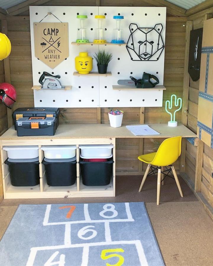 Neutral wood and black bin ikea trofast playroom ideas with playful pegboard wall and bright yellow chair by @househomelove. Organized craft and play space with tools and decor.